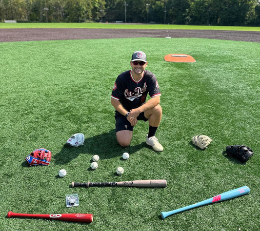 On-Deck Originals owner Dan surrounded by baseball gear. Jaw Bat, Homewood Bat, Split Grip, VukGripz, Akadema, Grace Glove, Valle Training Glove