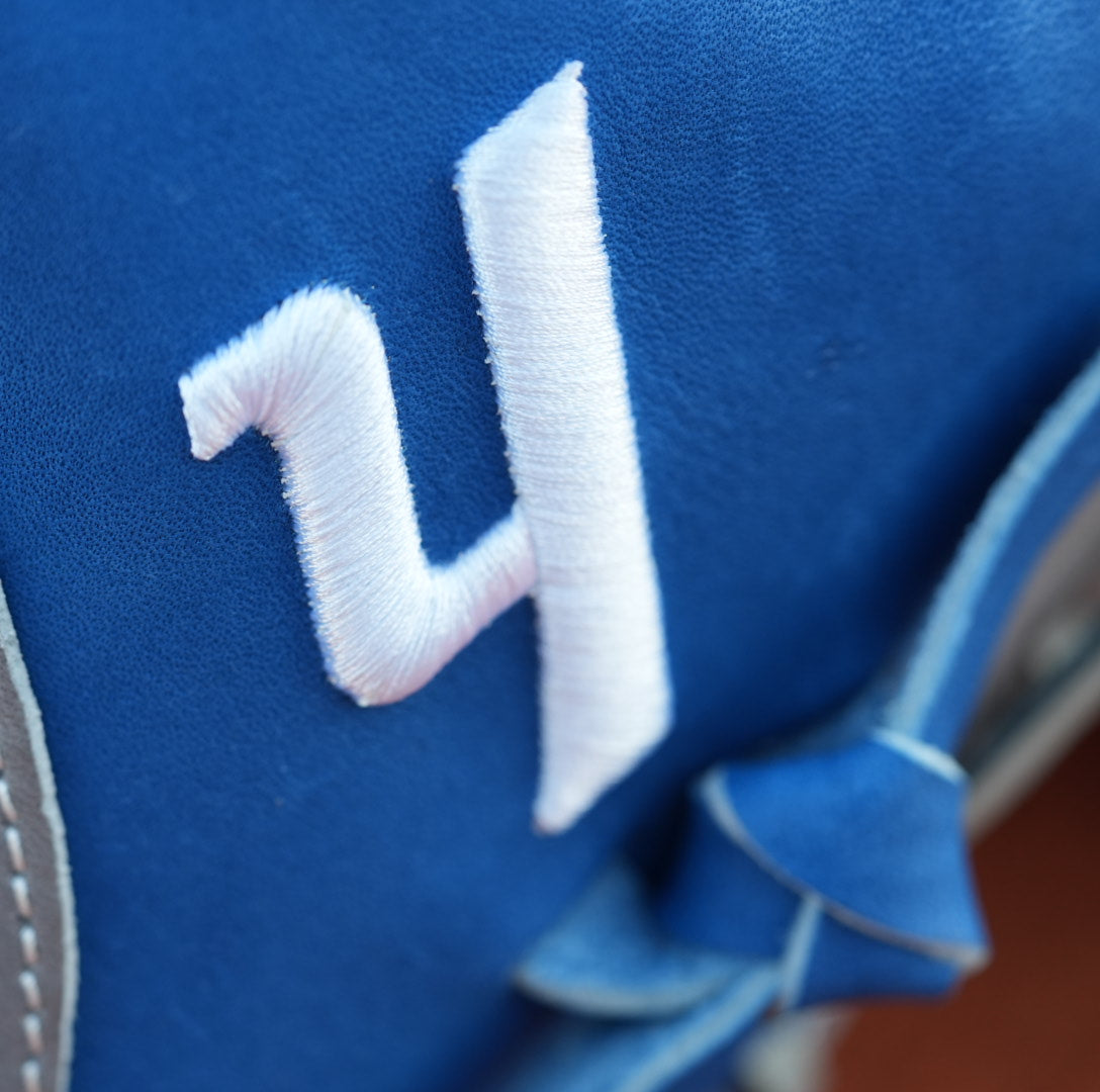 A white Yardley Y on a blue baseball glove