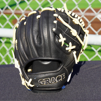 A black and blonde Grace Glove 9.5" training glove. Back of the glove next to as baseball field