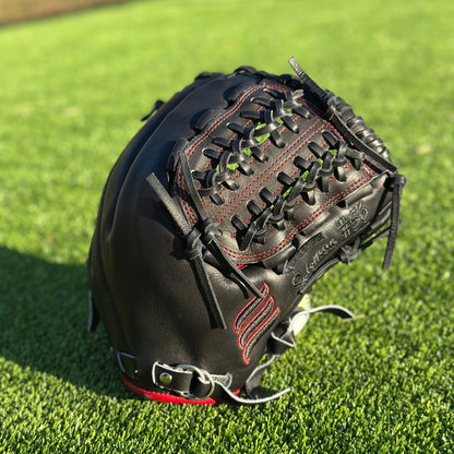 All black with red accent closed back semi-custom baseball glove. The Phantom, set on a turf baseball field