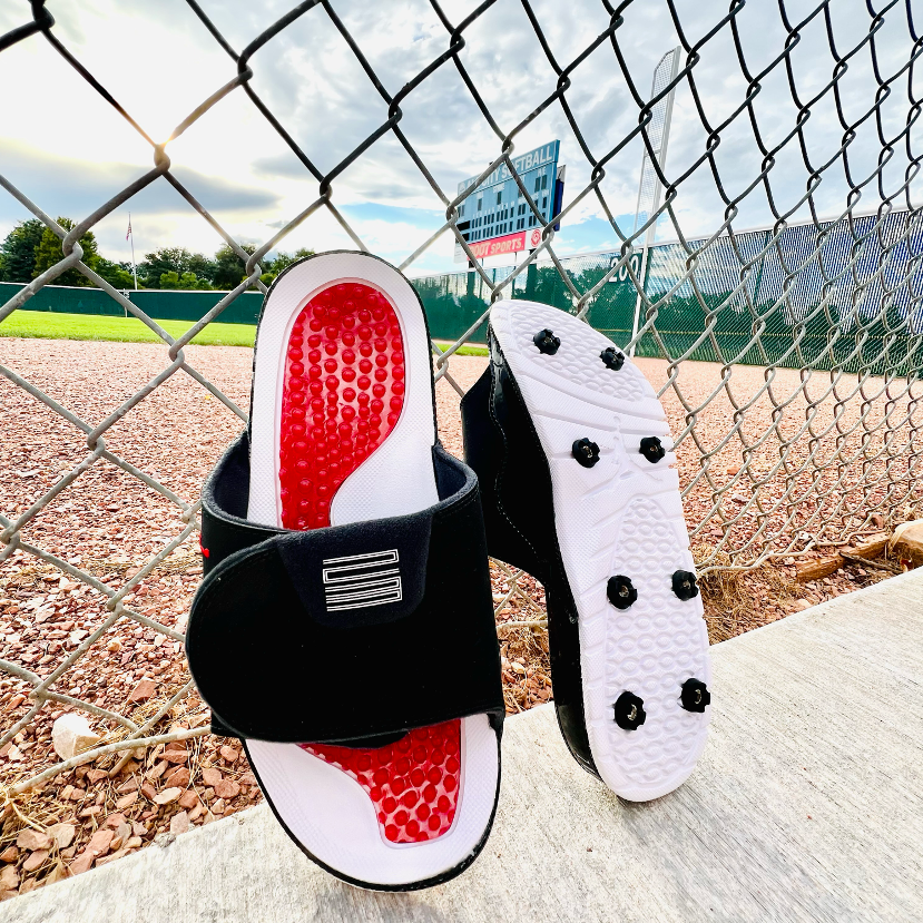 A pair of slide sandals with black Yardkick spikes installed