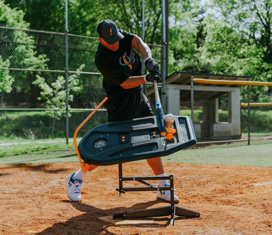 A baseball batter taking a swing on a baseball field with the Perfect Swings USA Swing Path Trainer V4